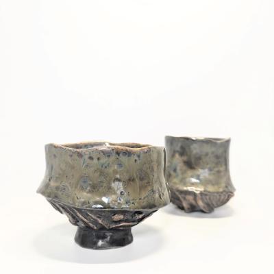 Two periwinkle blue ceramic cups with a base imprinted from a pumpkin, featuring wavy rims and a natural, stackable design